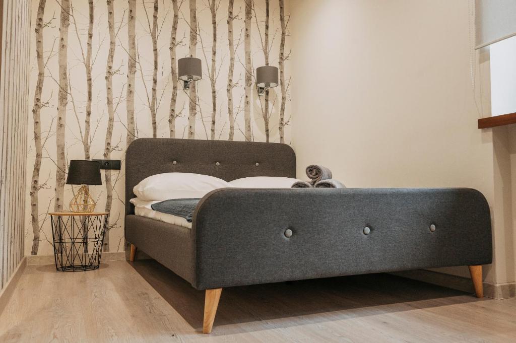 uma cama num quarto com uma parede em Niron Apartament Kapucyńska em Pila