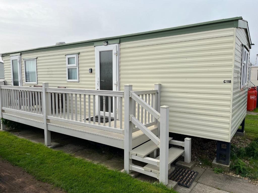 a mobile home with a porch and a deck at Golden Sands 6 Berth Beach front Ingoldmells beds made up for arrival WIFI in Ingoldmells