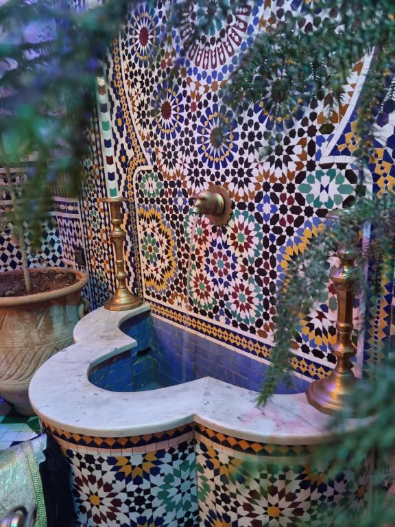 a tiled bench with plants inront of it at Riad Fes Touria Palace in Fez