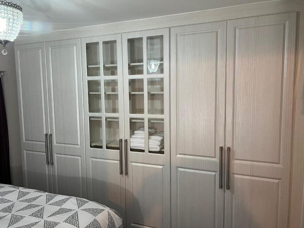 a white cabinet with glass doors in a bedroom at HAMS LODGE - - Strictly Only ONE GUEST ALLOWED IN ONE ROOM A SECOND ACCOMPANYING PERSON WILL NOT BE ALLOWED INTO THE PROPERTY in Birmingham
