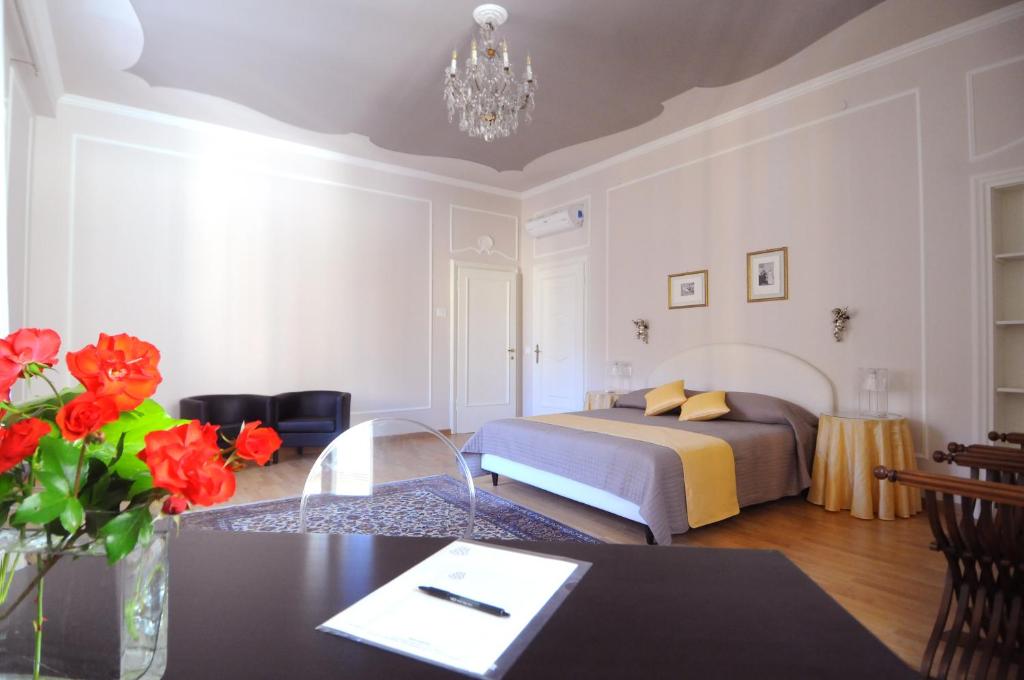ヴェローナにあるB＆B カングランデ ディ ダネーゼ ヴィヴィアーニのベッドルーム1室(ベッド1台、赤い花のテーブル付)