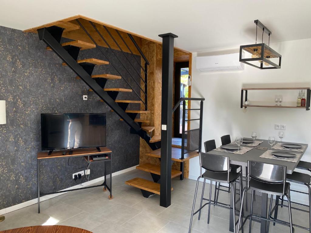 ein Wohnzimmer mit einer Treppe und einem Tisch mit Stühlen in der Unterkunft LA CASA in Olby