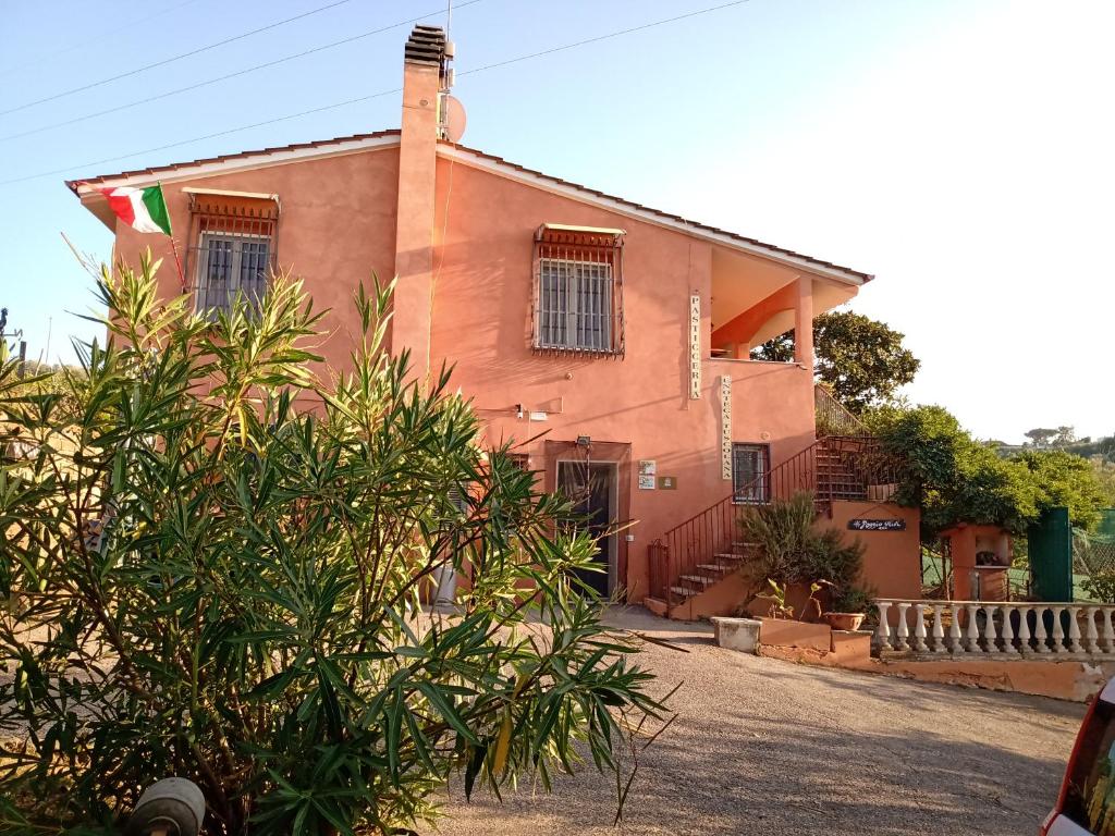 una casa de naranja con una puerta y un árbol en Poggio agli Ulivi, en Frascati