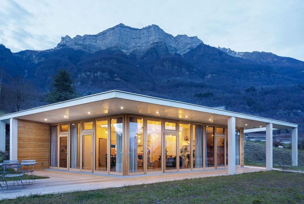 a large glass house with mountains in the background at Maison contemporaine de plain-pied-Classée 3*** in Fréterive