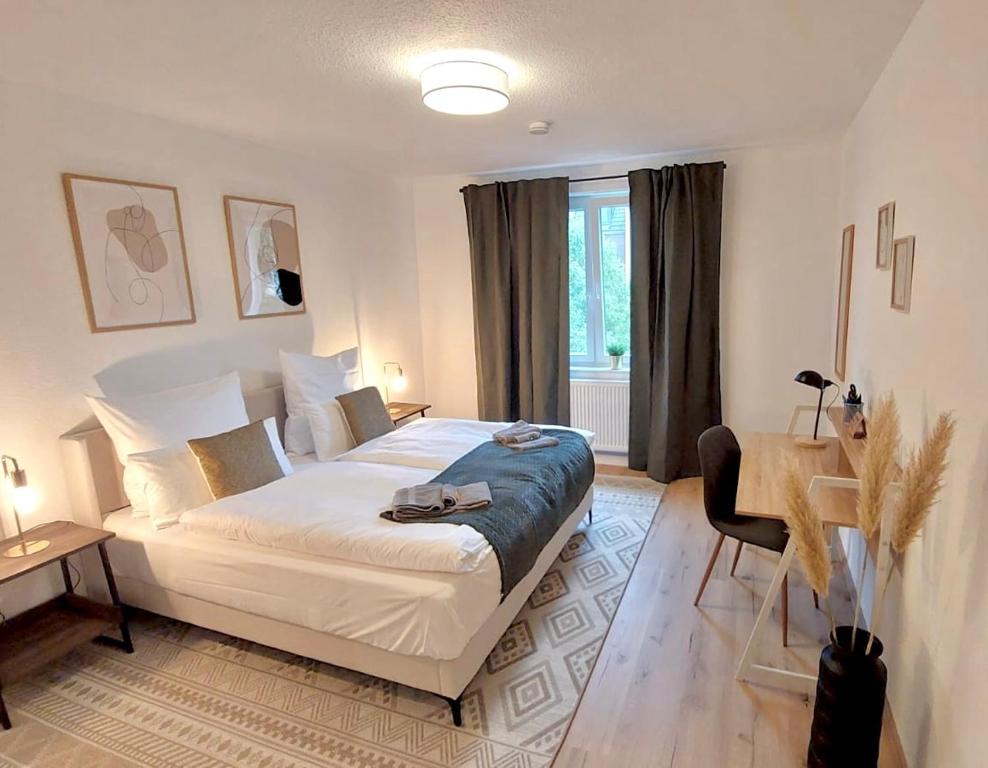 a bedroom with a bed and a table and a desk at Central for 8 - 2 Apartments - 2 kitchen - 4 beds in Bochum