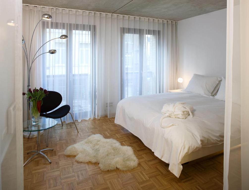 a bedroom with a white bed with a dog laying on it at Hotel Banks in Antwerp