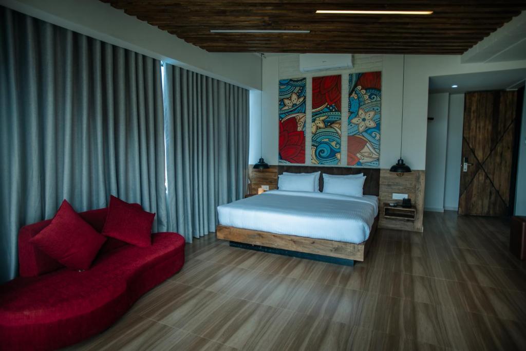 a bedroom with a bed and a red couch at Jade City Hotel in Pokhara