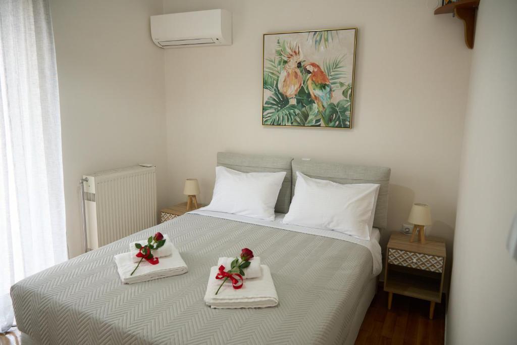 1 dormitorio con 1 cama y 2 toallas blancas con flores en Georgia's Comfort City Center apartment, en Tripolis