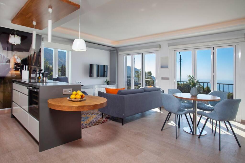 cocina y sala de estar con mesa y sillas en Luxury sea view apartment & pool, en Mijas