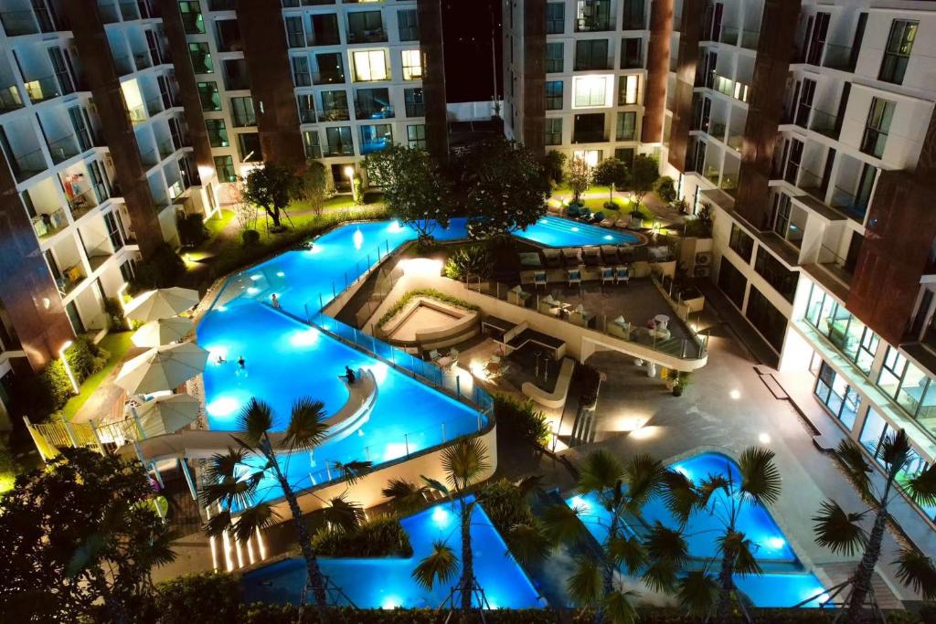 eine Aussicht über den Pool in einem Apartmentkomplex in der Nacht in der Unterkunft Near Central Festival- 5mims Walk- Infinity Pool & Comfort Room@The One Chiang Mai Condo in Chiang Mai