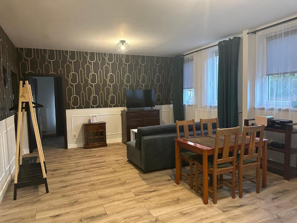 a living room with a couch and a table at Apartament Oksford 1 in Okszów