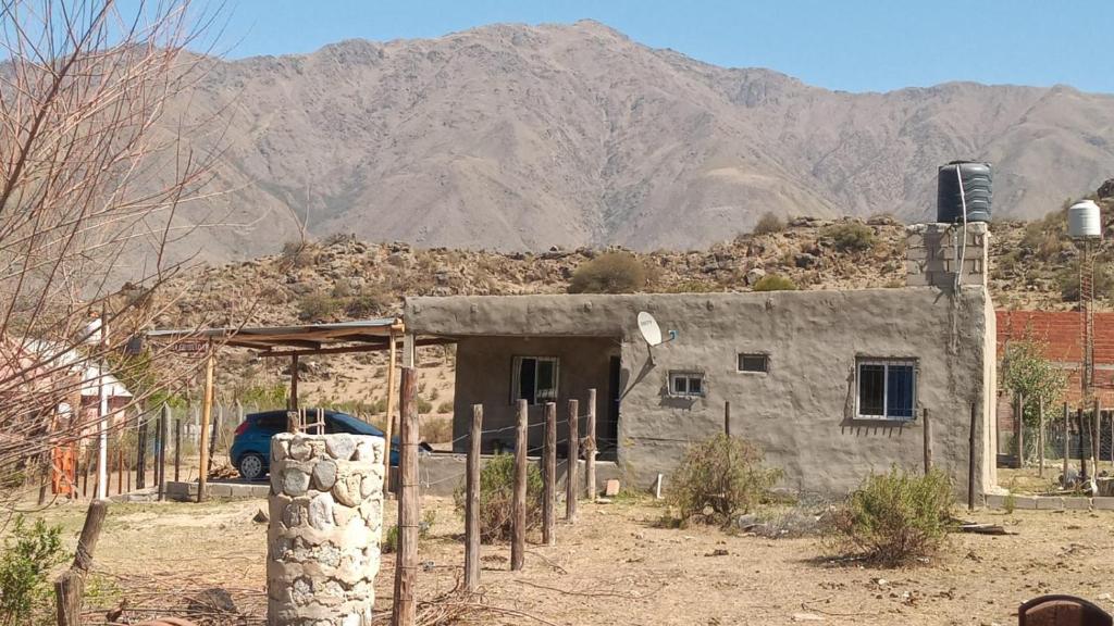 una pequeña casa frente a una montaña en La Griselda en El Mollar