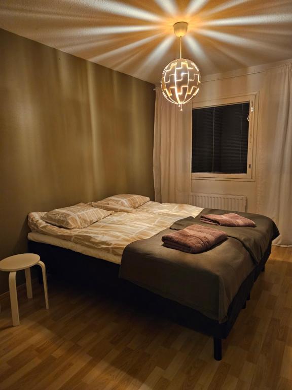 a bedroom with a large bed with a chandelier at Make yourself at home in Rovaniemi