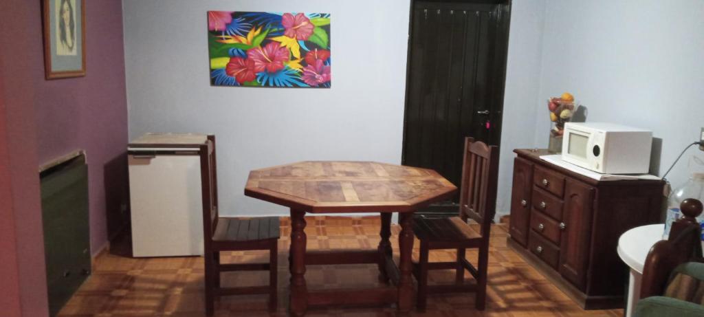 a kitchen with a table and chairs and a microwave at La casa de Angelita in Trelew