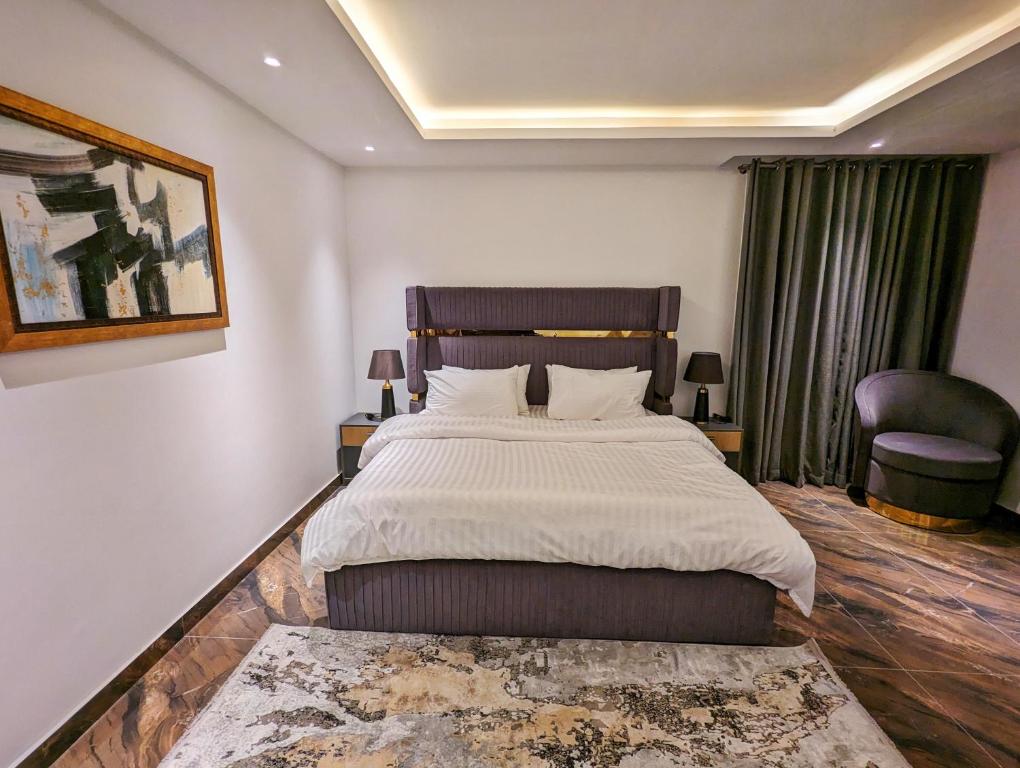 een slaapkamer met een groot bed en een stoel bij DHA Phase 4 Gold Crest Mall One Bedroom Serviced Apartment in Lahore