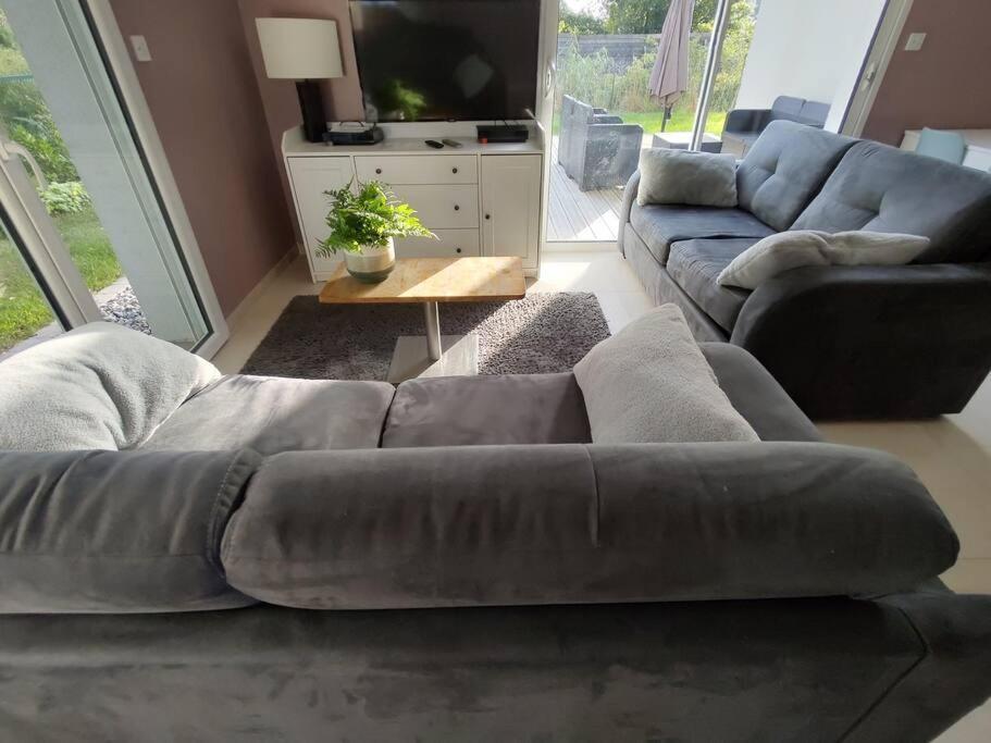 a living room with a couch and a television at Gite des 2 chênes entre Avenue verte, Lacs, Piscine et Casino in Forges-les-Eaux