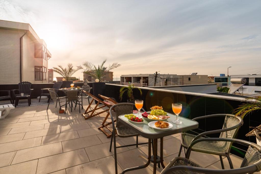 un balcón con una mesa con comida y copas de vino en Host Wise Arvore en Vila do Conde