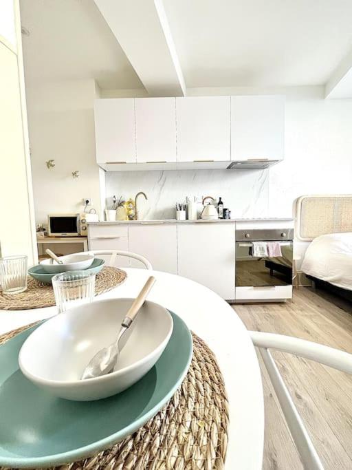 une cuisine blanche avec une table et une cuillère sur elle dans l'établissement Le Nacre 14 - Bourg-de-Péage, à Bourg-de-Péage