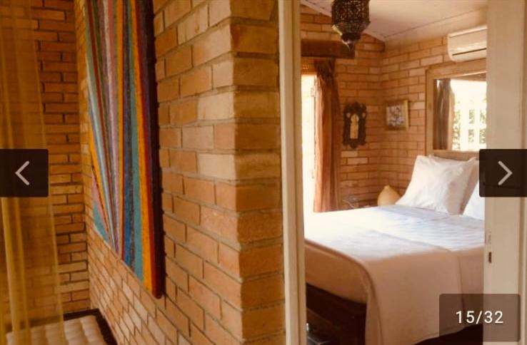 sypialnia z łóżkiem i ceglaną ścianą w obiekcie Villa Villagio di Mare w mieście Ilhabela
