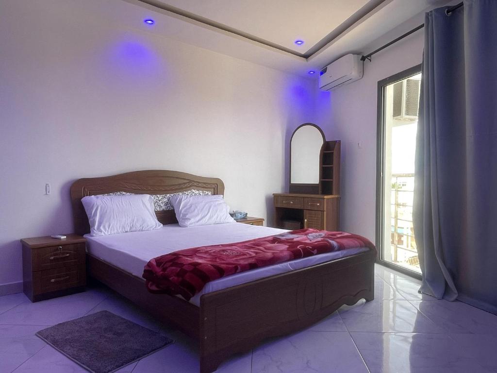 a bedroom with a large bed and a window at residence cheikh mahy cisse in Kaolack