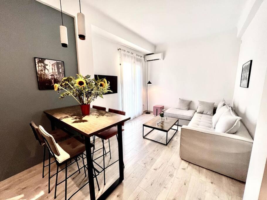 a living room with a table with flowers and a couch at Peaceful 3 Bedroom apartment in Athens center in Athens