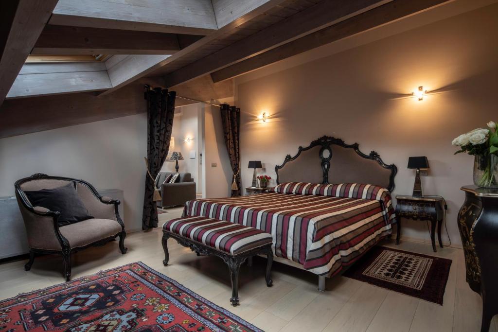 a bedroom with a king sized bed and a chair at Hotel Residenza la Ceramica in Fabriano