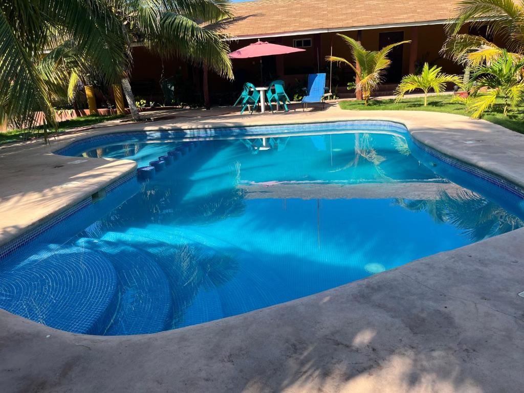 - une piscine d'eau bleue en face d'une maison dans l'établissement Cabañas vero, à Caleta de Campos