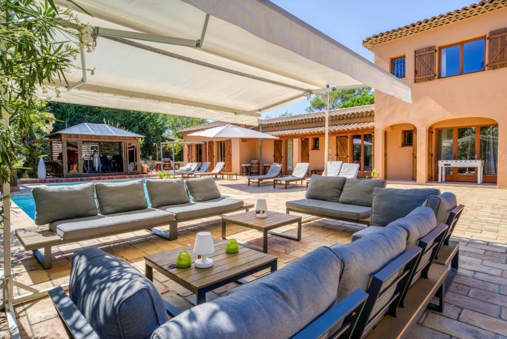 une terrasse avec des canapés et des tables dans l'établissement Villa Golf les Cigales, à Mouans-Sartoux