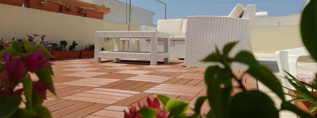 un miroir et une chaise sur la terrasse dans l'établissement Ramzam - Spacious & Modern 3 bedroom apartment with roof terrace, à Marsaskala