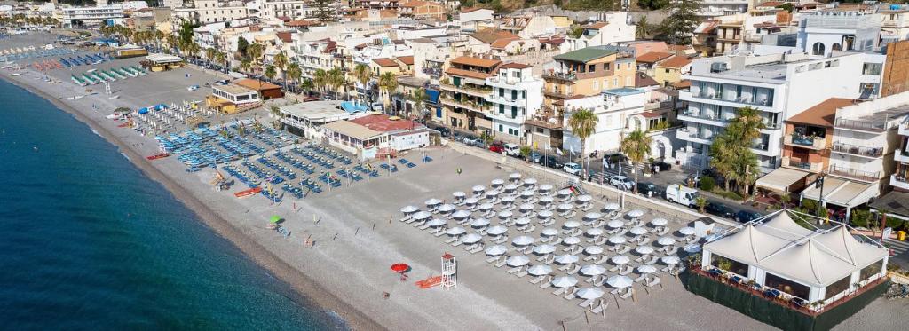 - une vue aérienne sur une plage avec des parasols et des chaises dans l'établissement Perla de Mar a 20m dalla spiaggia, à Letojanni