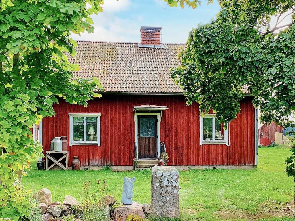 a red house with a red door in the yard at Holiday home MARIESTAD XI in Mariestad