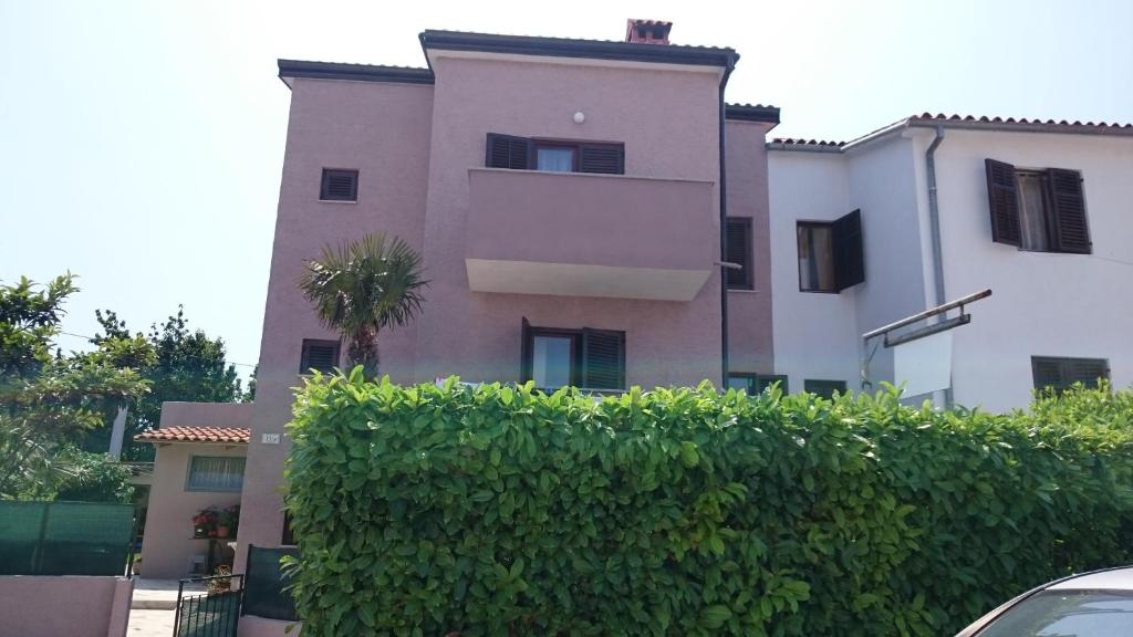 a building with a hedge in front of a building at Apartments Jaklin Rovinj in Rovinj