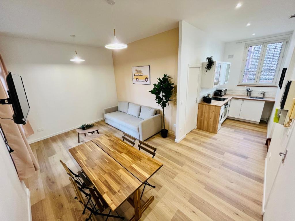 un salon avec une table et un canapé dans l'établissement Orangeraie, à Rouen