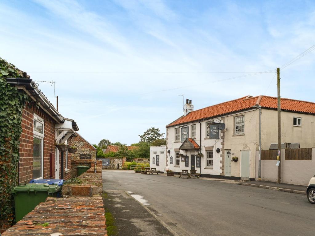 an empty street in a town with white buildings at Rose Cottage in Skipsea