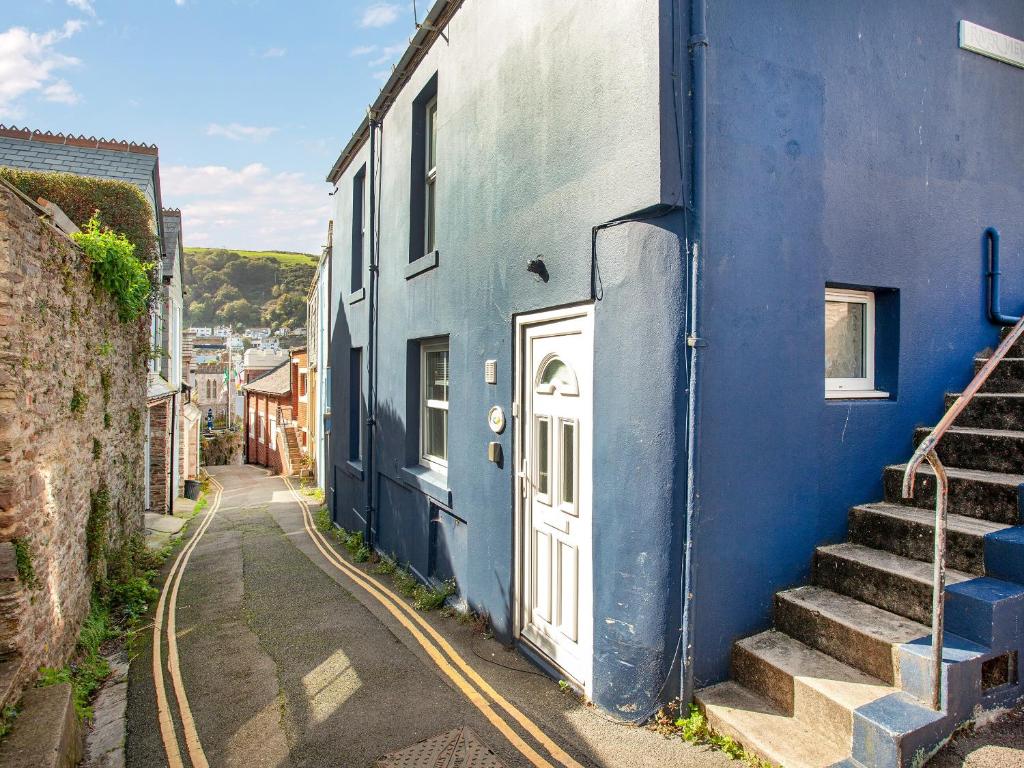 a blue building with a white door on a street at Captains Lockyer in Kingswear