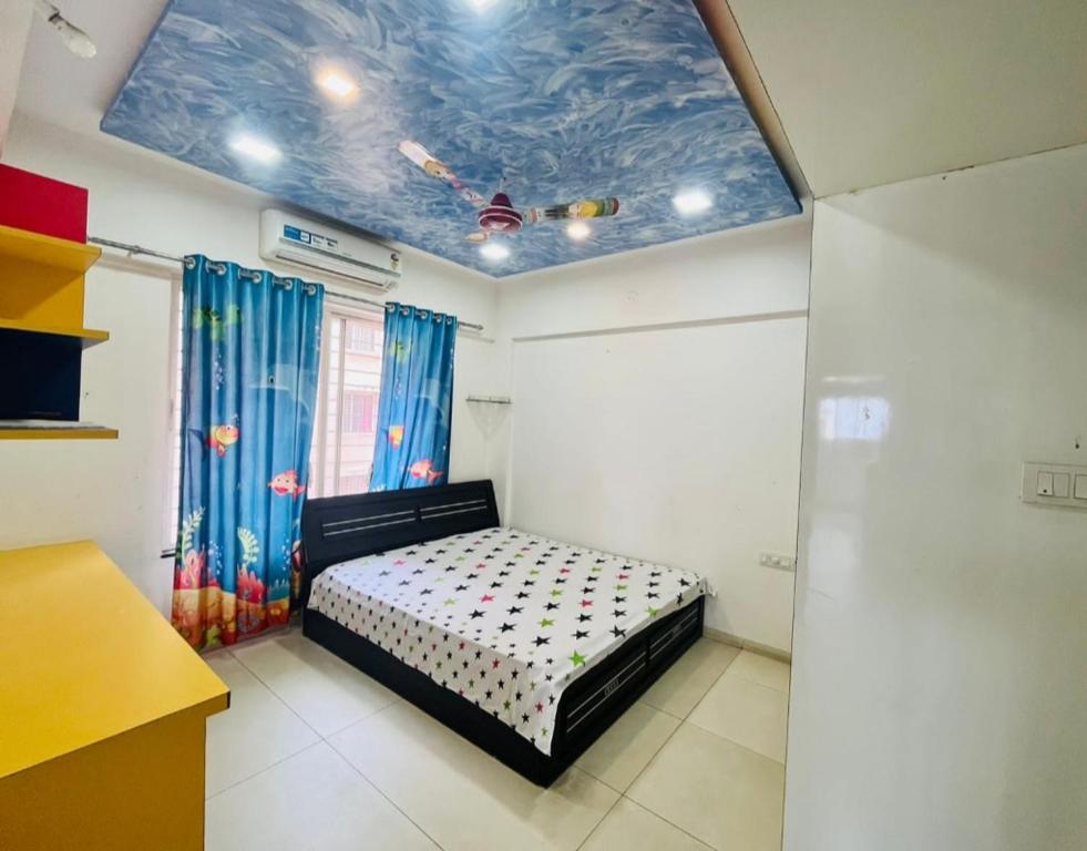 a bedroom with a bed and a blue ceiling at kolte patil 24k allura in Pune