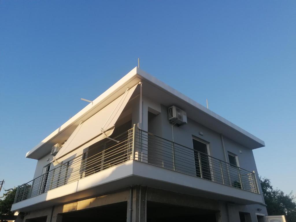 a building with a balcony on top of it at Anemos House in Anemokhórion