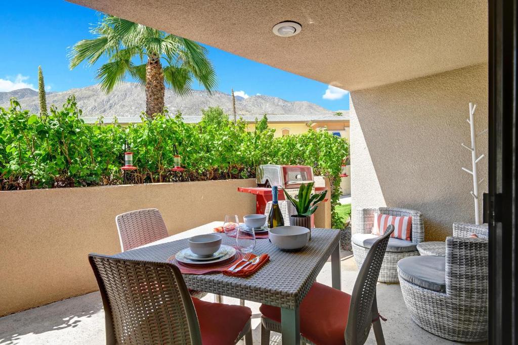 een tafel en stoelen op een patio met uitzicht op de bergen bij Modern Plaza Villas Oasis in Palm Springs