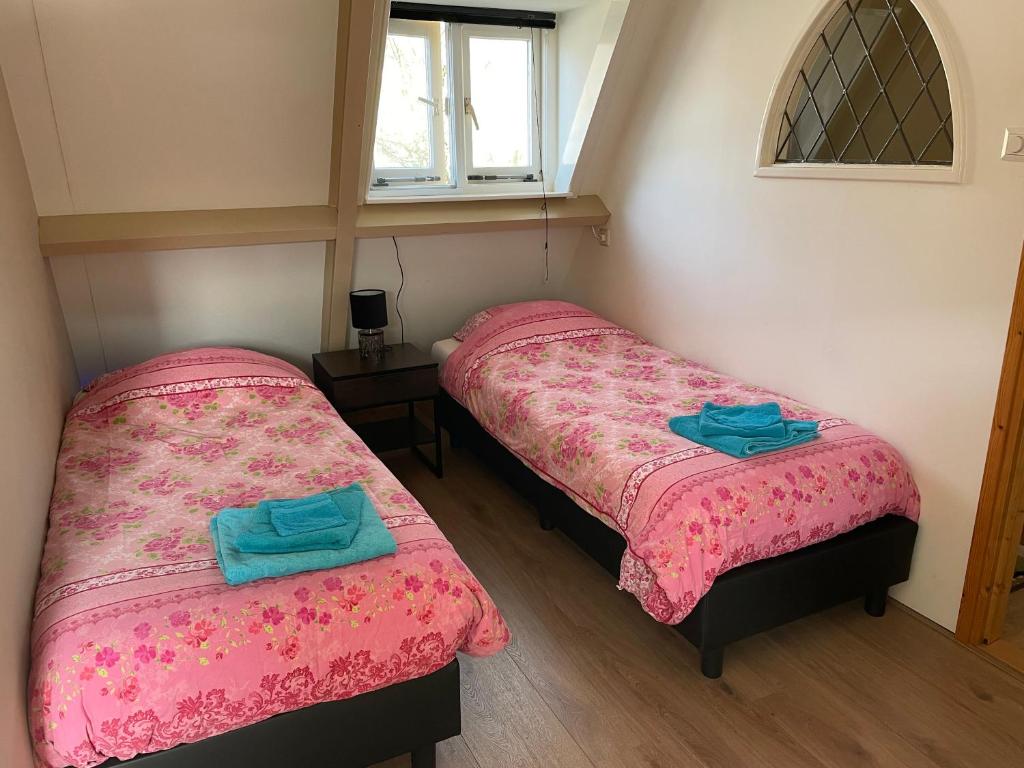 two twin beds in a room with a window at Holiday in Spakenburg t Afferhuus in Spakenburg