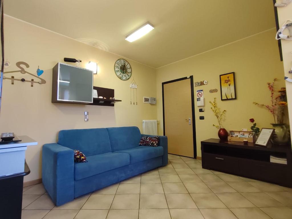 a living room with a blue couch and a tv at Residenza tra Parma e Fiere in Baganzola