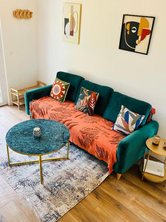 un salon avec un canapé vert et une table dans l'établissement Maison Evasion Voyage parking et jardin by Art de Voyager, à Étretat