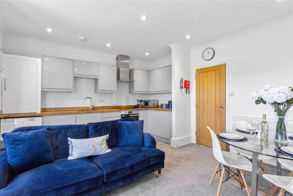 a living room with a blue couch and a table at Ahoy There! in Hythe