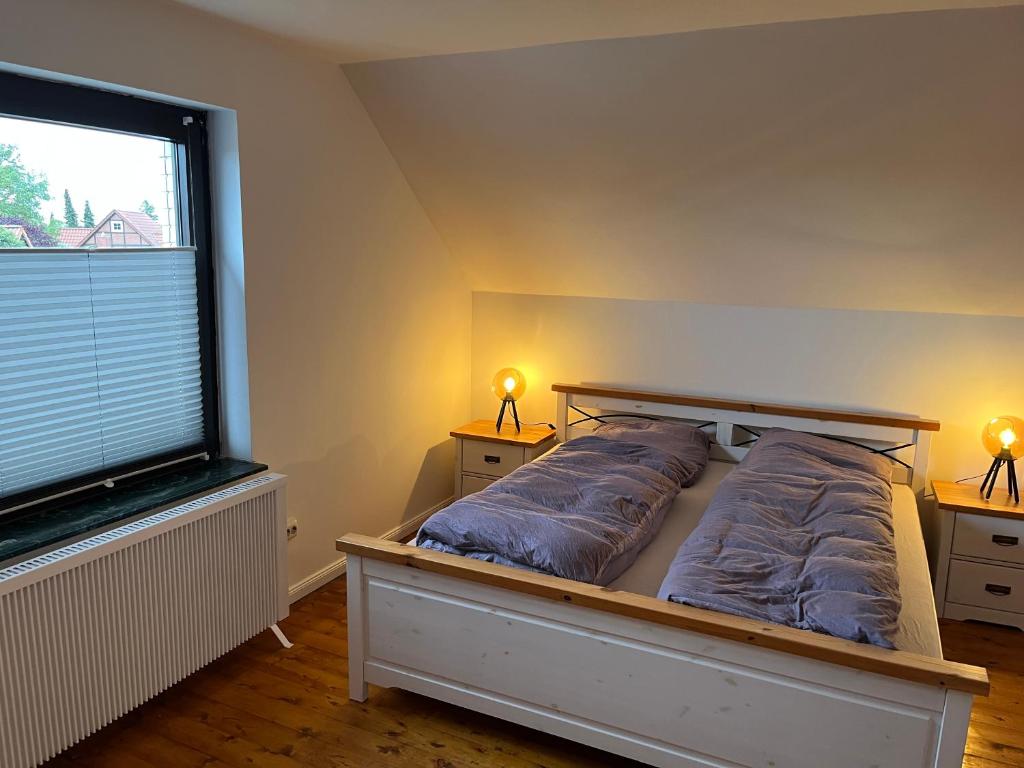 a bedroom with a bed and a large window at Ferienwohnung Am Langenberg in Hitzacker