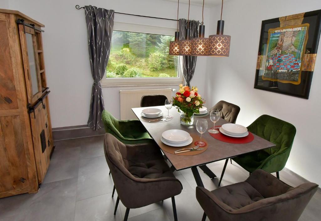 a dining room with a table and chairs and a window at Ferienhaus am Bach in Koblenz