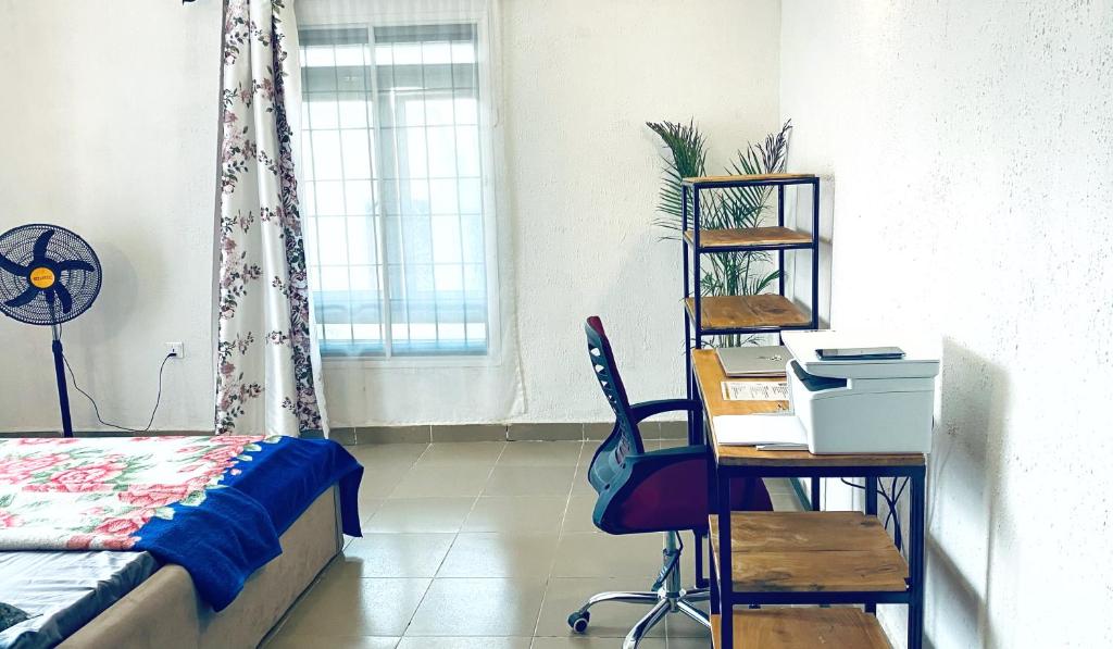 a bedroom with a bed and a desk and a chair at Cozy Apartment in the City Centre - Rayfield Jos in Zawan