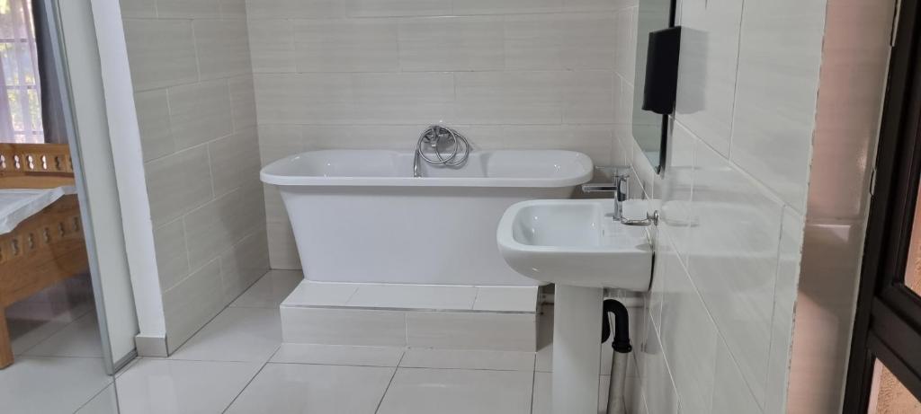 biała łazienka z umywalką i toaletą w obiekcie LAPA ROOF w mieście Sandton