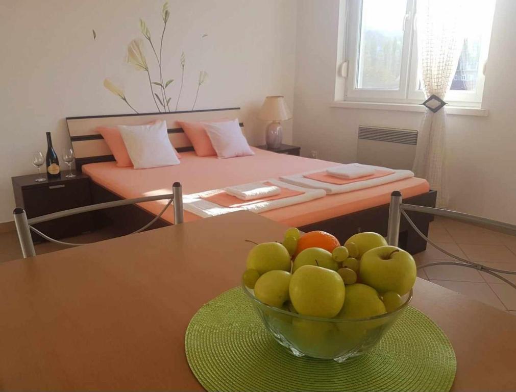 un plato de fruta en una mesa en un dormitorio en Idila Kovilje, en Banja Koviljača