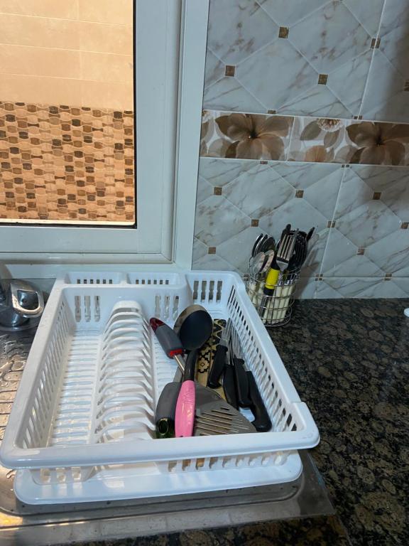 a white plastic container with utensils in it at Luxurious Family Holiday Home in Temara