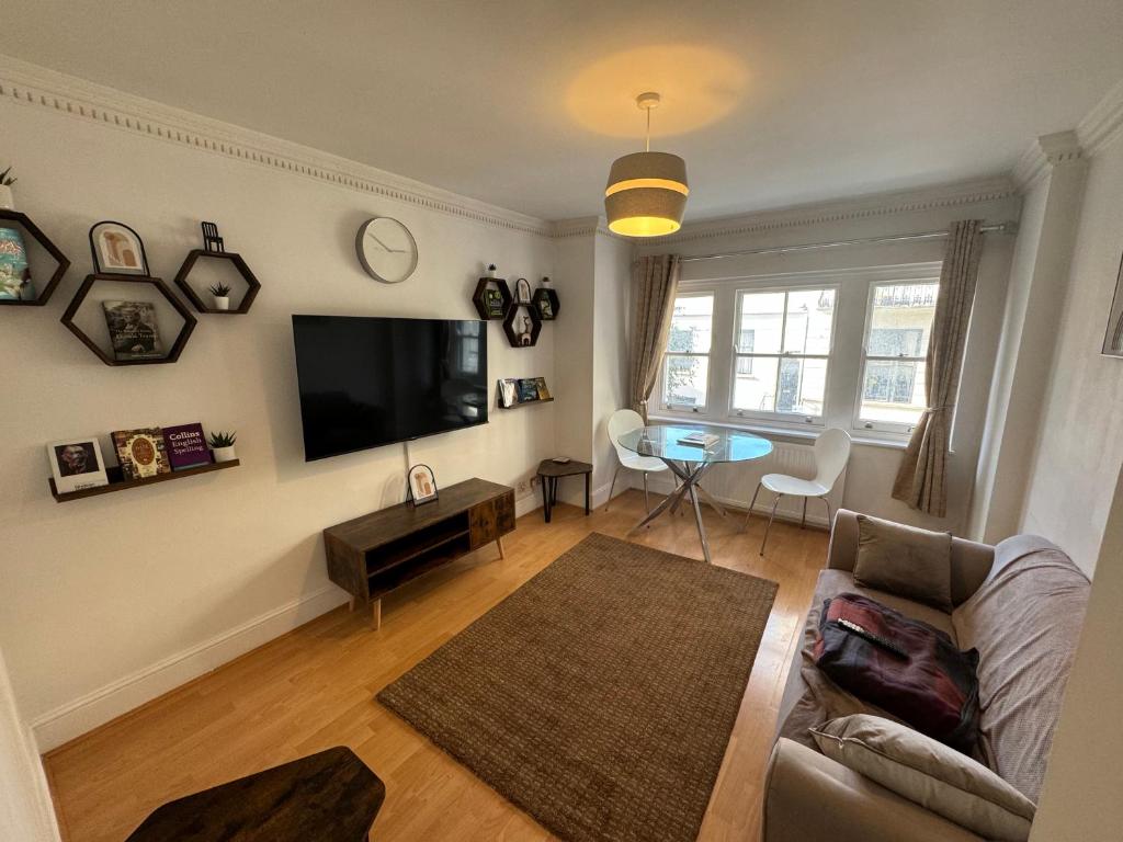 ein Wohnzimmer mit einem Sofa und einem Flachbild-TV in der Unterkunft A stunning apartment in Paddington in London