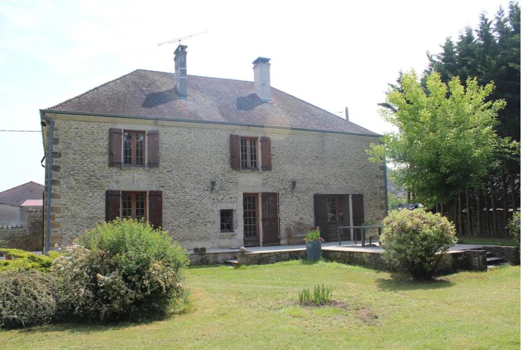una vieja casa de piedra con un patio delante en Charme en Champagne en Trémilly